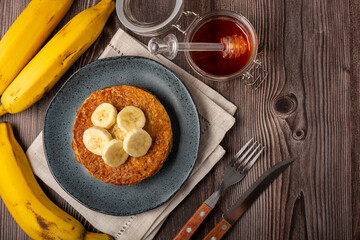 Banana oat pancakes topped with sliced ​​bananas and honey.