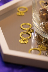 golden ring cutouts rest on a mirror centerpiece for a bridal shower party decoration