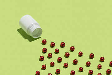 Christmas decoration creative idea with red baubles and pill package on bright green background. Minimal visual composition, abstract surreal concept.
