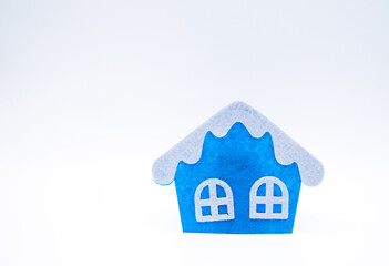 Handmade flat toy in form of house with white roof and windows on it