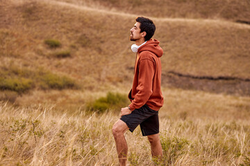 Athlete man running sport. Runner take a break during jogging outdoors with beautiful landscape around. In nature. Male with headphones enjoy the view scene surrounding him, in contemplation