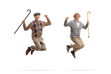 Full length portrait of cheerful elderly men with walking canes jumping