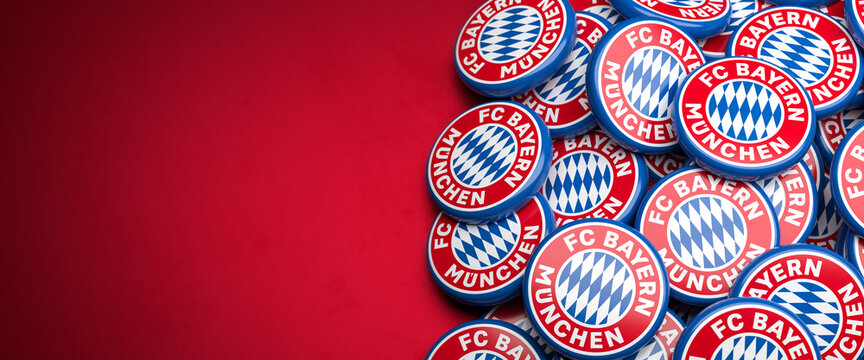 Logos Of The German Soccer Club FC Bayern Munich On A Heap On A Table. Copy Space. Web Banner Format