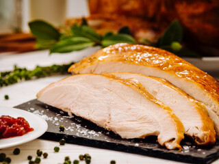 Close up shot of carved festive platter of white and juicy roasted turkey meat on black contrast...