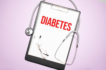 Paper with text diabetes on blue background with stethoscope and pills