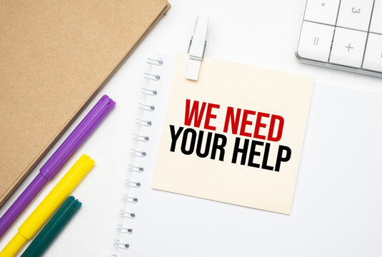 We need your Help. Notebook on laptop keyboard, on light background