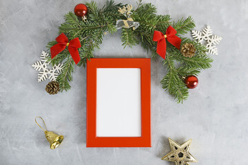 Fototapeta na wymiar New year mockup: christmas tree branches with red photo frame on grey background. Holidays concept. Text space