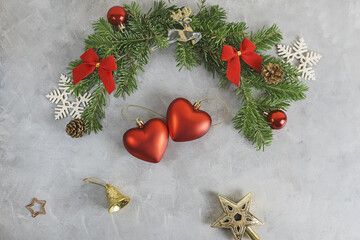 Top view flat lay christmas background with festive decorated pine tree branches with two heart shaped. toys. New year, love, romance