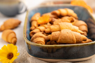 Homemade bagel roll with cup of coffee on a gray concrete background. side view, close up, selective focus.