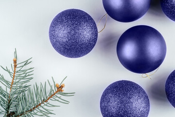 Color of the Year 2022. Trendy background of Christmas shiny balls with christmas tree brunch. Copy space