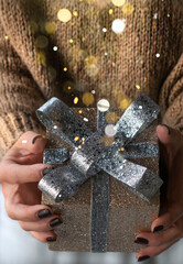 Sparkling blurred gift box in woman's hands