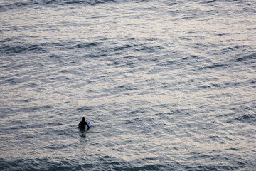 Surfer in the ocean waiting for waves