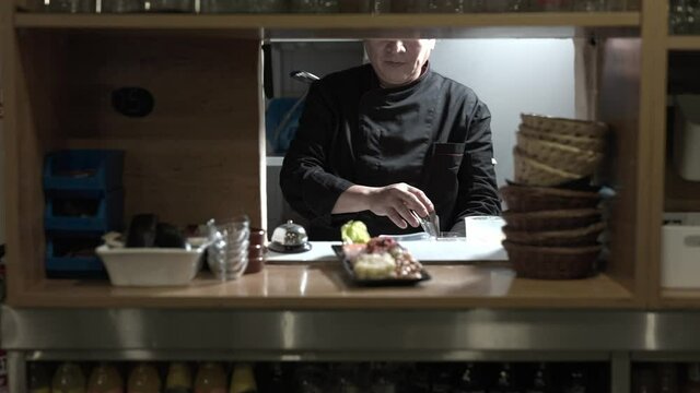 Peruvian ceviche. Senior Latin chef in uniform ring the bell for cuisine service. Slow motion 4k