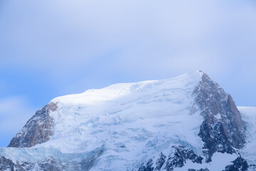 Fototapeta na wymiar Le Mont Blanc du Tacul partiellement éclairé en France, en Auvergne-Rhône-Alpes, en Haute Savoie, vers Chamonix, en hiver lors d'une journée ensoleillée.