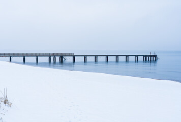 Long wooden jetty on Angelholm beach during winter on the Swedish West Coast. Selective focus.