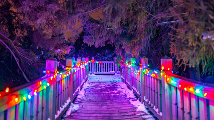 Wood walkway with glowing Christmas lights at night