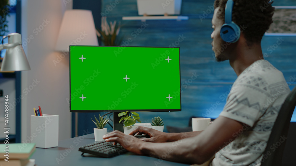 Poster african american man working with horizontal green screen on computer monitor. black person with hea