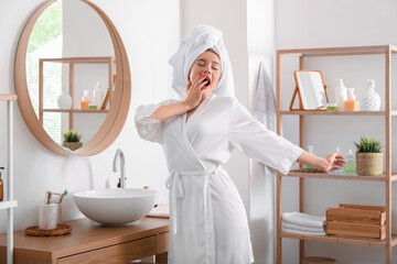 Pretty young woman stretching in bathroom after morning shower