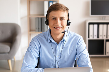 Young consultant of call center with headset working in office