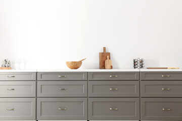 Modern kitchen drawers and utensils in light room