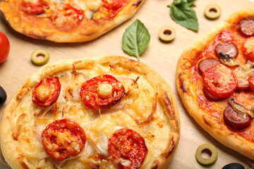 Delicious mini pizzas on wooden background, closeup