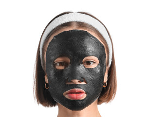 Young woman with activated charcoal mask on her face against white background