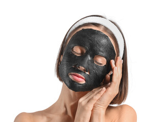 Young woman with activated charcoal mask on her face against white background