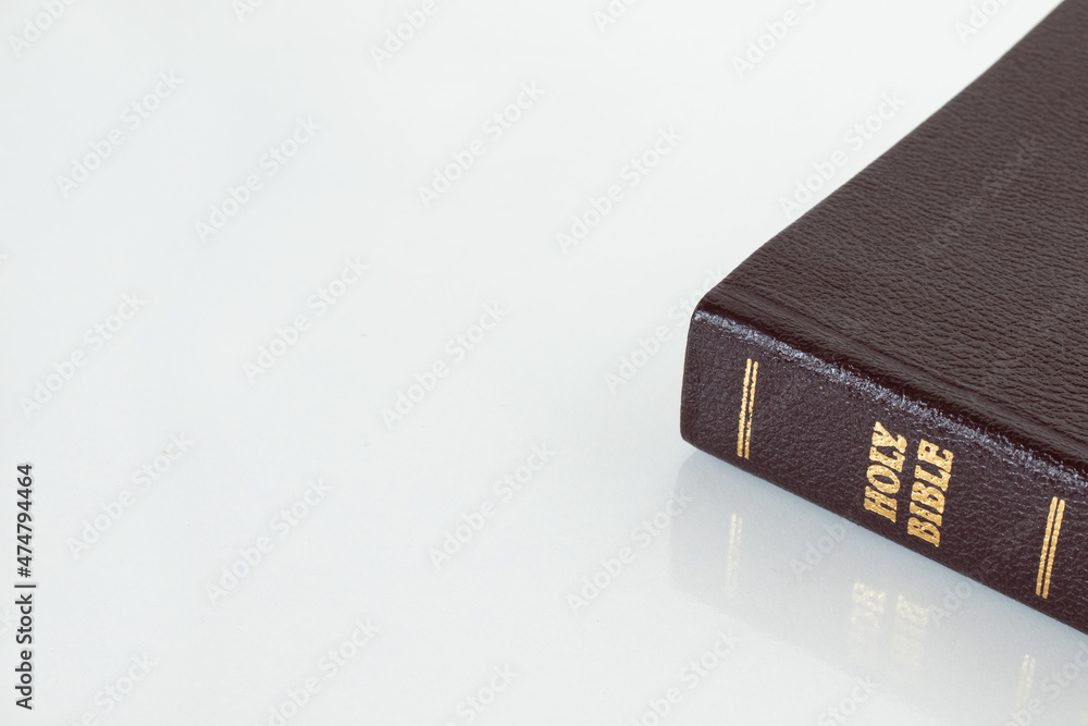 Wall mural Closed Holy Bible Book on white background. Copy space for text. Gold text on Christian Scripture. A biblical concept of love, faith, hope, trust in God Jesus Christ. A close-up. Isolated object. - Wall murals