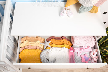 Fototapeta na wymiar Drawer with baby clothes in children's bedroom