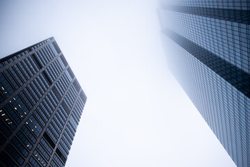 Business center in the tower skyscraper in the financial downtown center of the city in the foggy misty day with cover by clouds tops. Financial business abstract architecture concept.