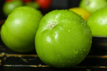 Fresh green tomatoes with water drops, closeup