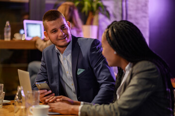 Two business people having a meeting in a cafe while using a laptop