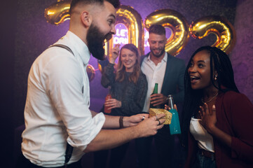 Happy beautiful couple celebrate New Year's Eve and exchanging gifts