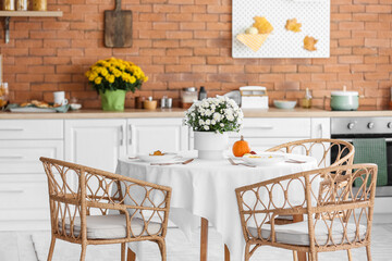 Dining table with beautiful Chrysanthemum flowers in interior of modern kitchen