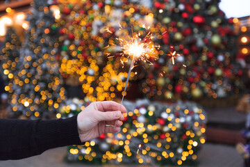 Two hands with sparklers on a Christmas or New Year's eve background