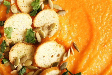 Texture of delicious pumpkin cream soup and croutons, closeup