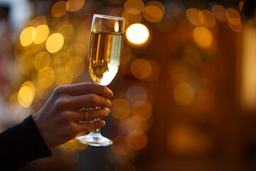 Human hands with glasses of champagne on a Christmas or New Year background