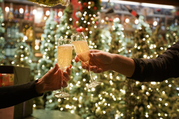 Two hands with glasses of champagne on a Christmas or New Year background