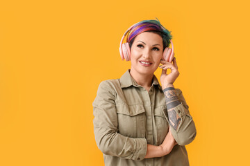 Beautiful woman with unusual hair listening to music on color background