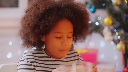 Little girl enjoying festive food at Christmas dinner table, family traditions