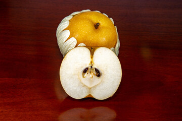 Isolated Asiatic pear or nashi pear (Pyrus pyrifolia) on rustic surface in selective focus