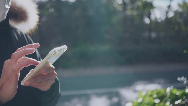 外でスマホを操作する人