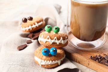 Funny cookies with cup of coffee on table