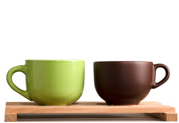 two brown and green cups of coffee or tea on wood with white background
