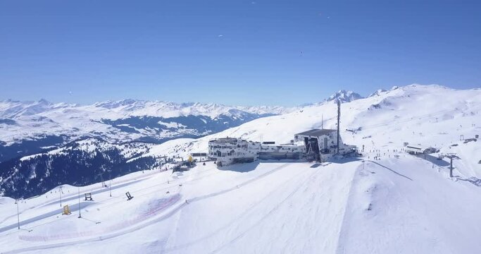 Backwards ascending footage of winter mountain scenery. Sport in nature on sunny day. Snow covered landscape. Laax, Switzerland