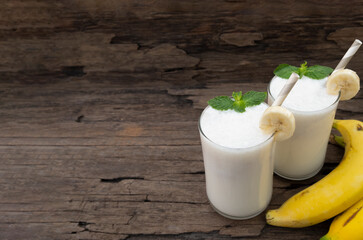 Banana fresh cocktail vanilla smoothies  fruit juice beverage healthy the taste yummy in glass drink episode good morning on wooden background from the top view.