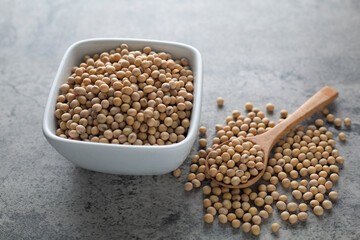 Soybean raw food nutrition in wooden spoon on a pile