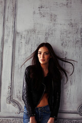 young brunette woman in leather jacket at vintage wall, lifestyle people concept