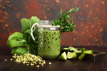 Jar of healthy green smoothie and vegetables on grunge background