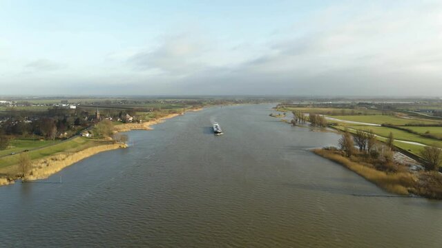 Scenic aerial drone view of big boat sailing Lek river in Ameide dutch city